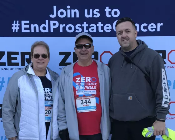 Three people standing at a prostate cancer event 