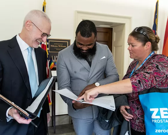 Three advocates looking at papers inside of folders at the Capitol 