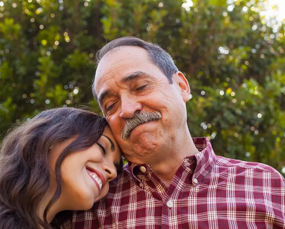 Older Hispanic man and his daughter leaning on his shoulder