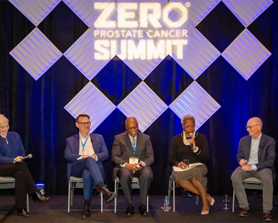 A group of panelists sitting on stage at the Summit