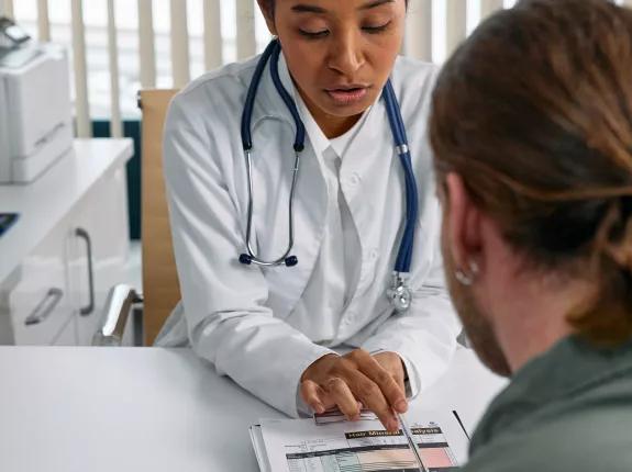 White female doctor reviewing patient's file with a male patient