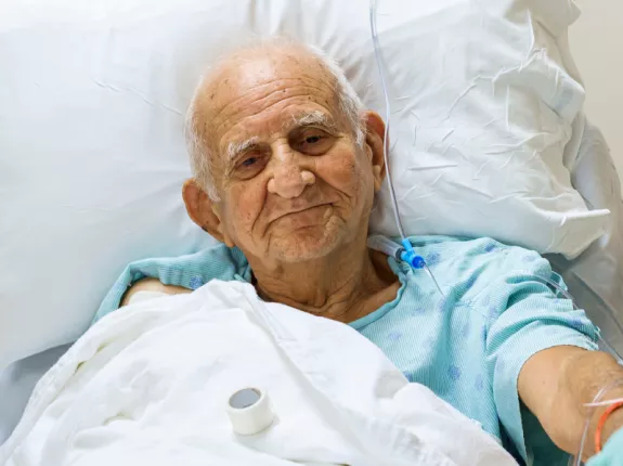 A senior man laying in a hospital bed