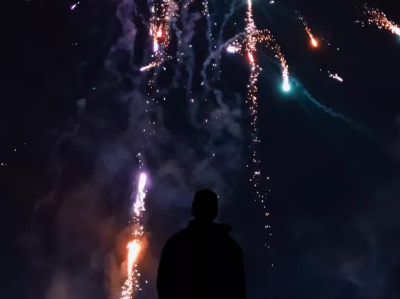 Silhouette of Person in Front of Fireworks