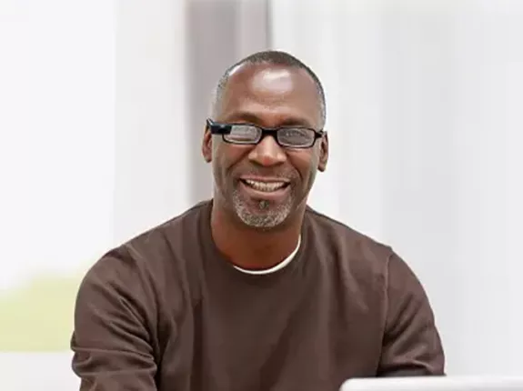 Black man sitting in front of his laptop