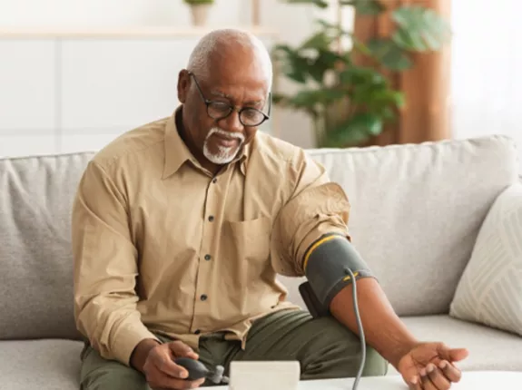 An older Black man taking his blood pressure test