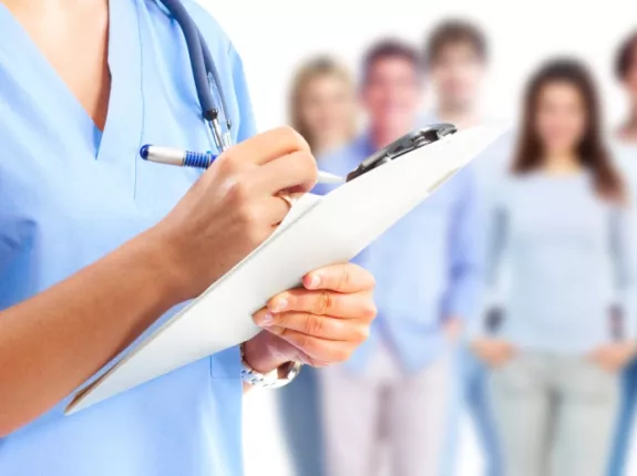 Medical professional holding a chart in front of a group of people