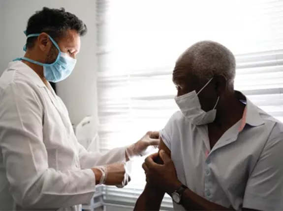 Black man holding up his sleeve for a doctor