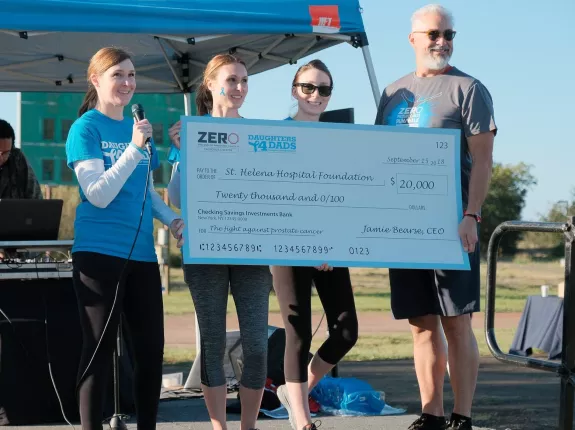 Group of people holding a massive check