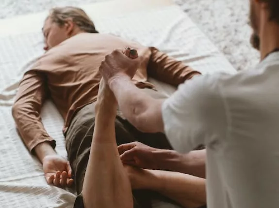 Man getting his legs and pelvic floor stretched out