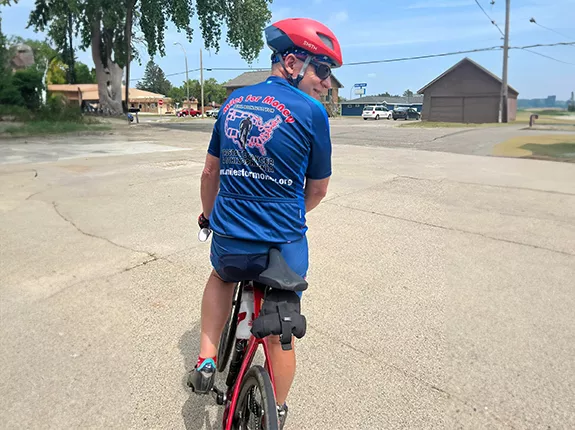 Scott Freitag on his bicycle wearing a Miles for Money jersey