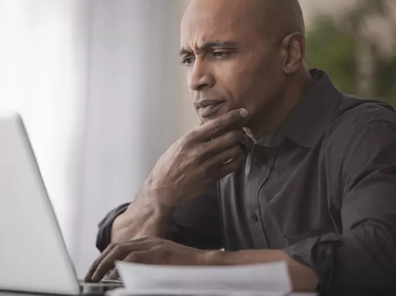 Middle aged black man looking at laptop