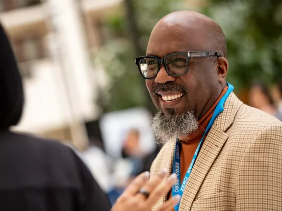 Reggie Tucker-Seely smiling while he talks to another person