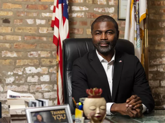 LaShawn Ford sitting in chair at desk with american flag behind