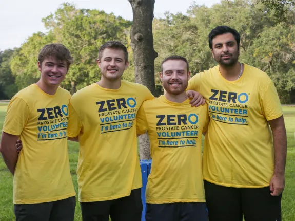 A group of four young men wearing yellow ZERO Volunteers t-shirts at the Tampa Run/Walk event in 2023