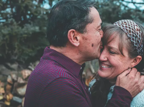 Man kissing woman on forehead