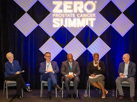 A group of panelists sitting on stage at the Summit