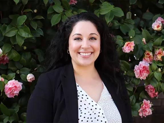 Headshot of Victoria Vighetto in front of flowers