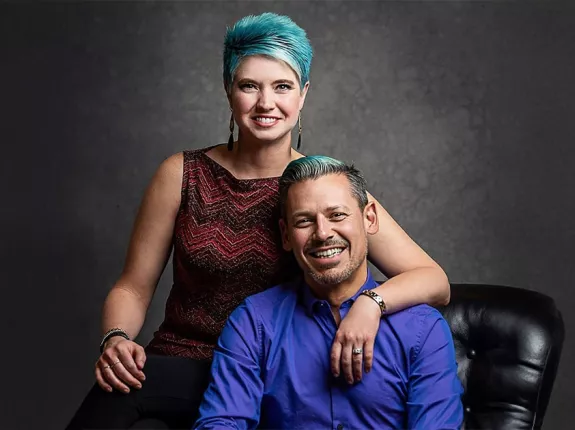 Brandy and Leo Nunes sitting on a black couch