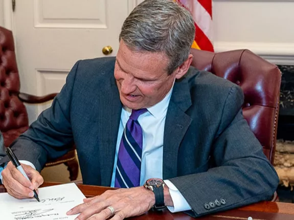 Governor Lee sitting at desk signing bill into law