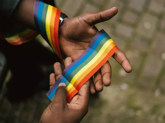 Hand holding a rainbow string