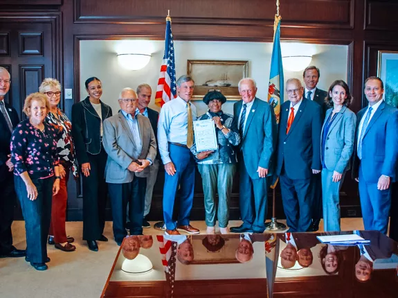 A large group standing in the office of the Delaware governor