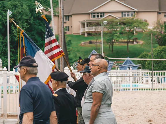 Veterans standing to the left with the American flag