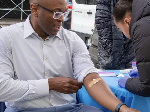 Man sitting at a table getting his blood drawn