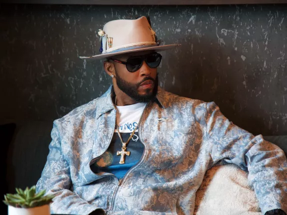 Montell Jordan in light blue jacket sitting