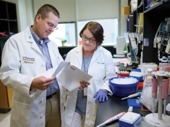 Two prostate cancer researchers review findings together in a medical laboratory.