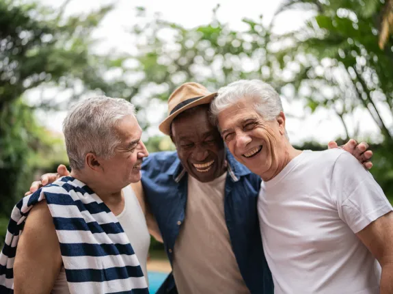 three men smiling outside