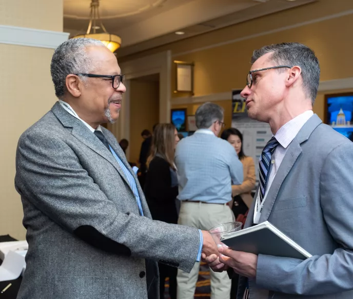 Two men in grey suits shaking hands