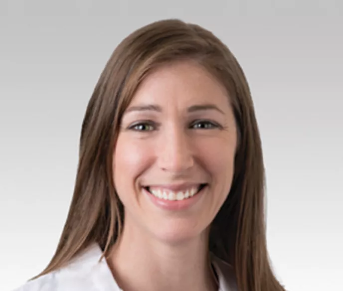 Woman with long brown hair in a white coat, Dr. Alicia Morgans