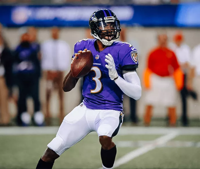 NFL quarterback, Robert Griffin III, getting ready to throw a football on the field in a Baltimore Ravens uniform