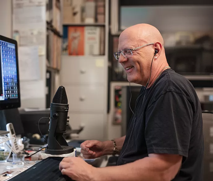 Jay Jay French in front of a microphone and computer