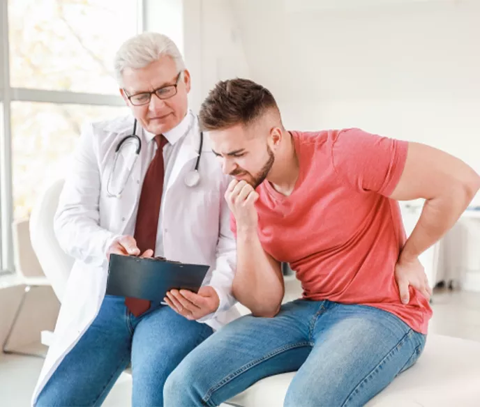 A man sitting next to his doctor looking at a clipboard