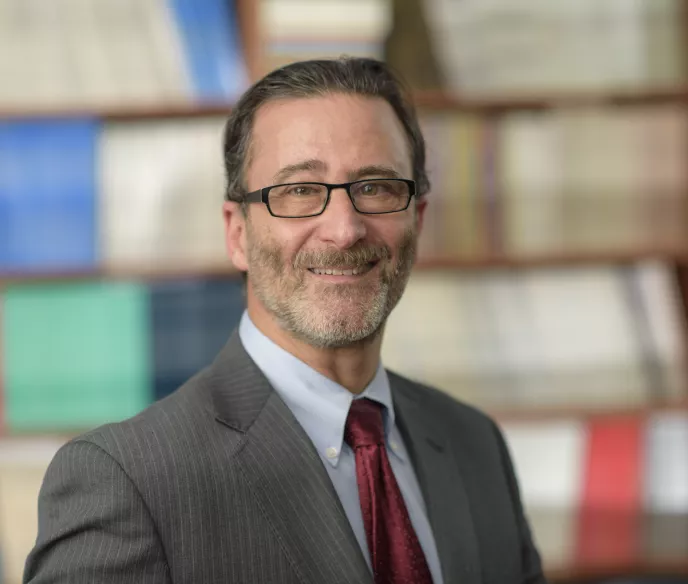 A man wearing a suit and tie standing in a library