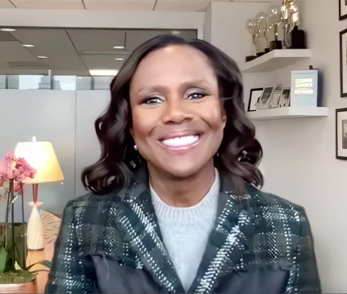 A black woman in a plaid blazer
