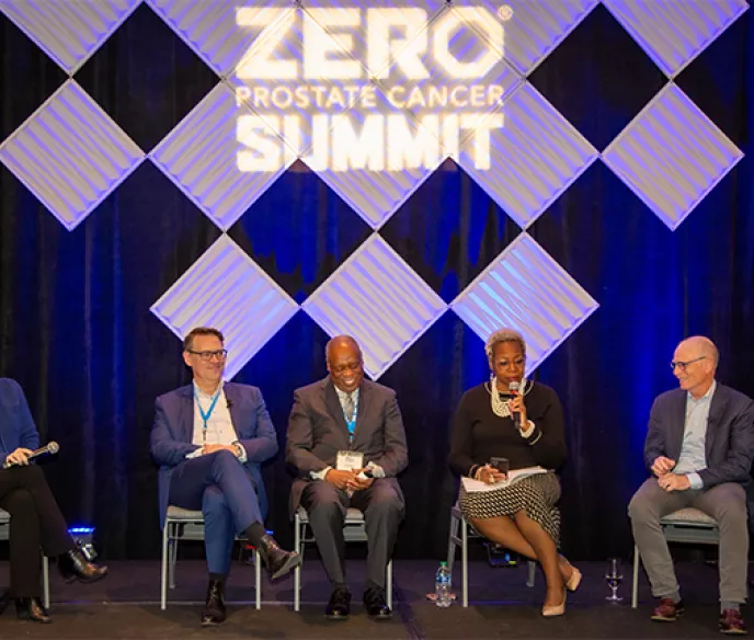 A group of panelists sitting on stage at the Summit