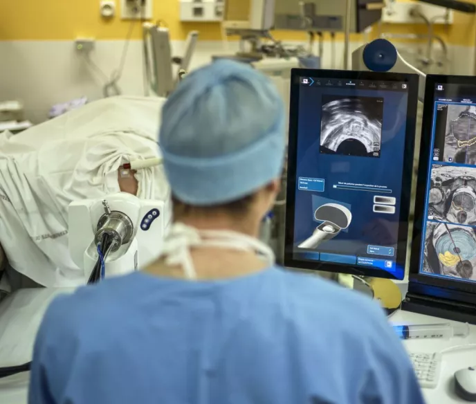 A doctor in a medical room with a monitor up showing images of someone's prostate