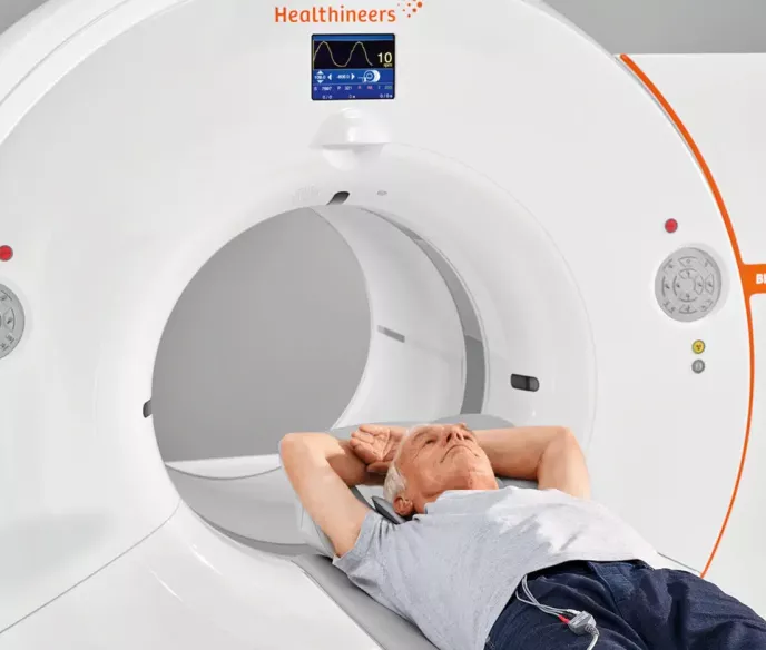 A white male laying in a radiograph machine for a PSMA PET image