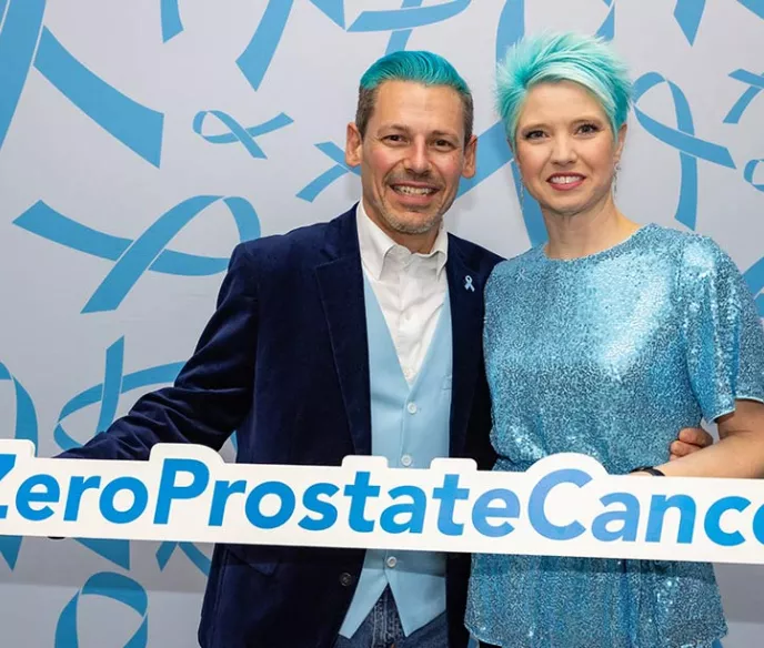 Man and woman with blue hair holding sign that says #ZeroProstateCancer