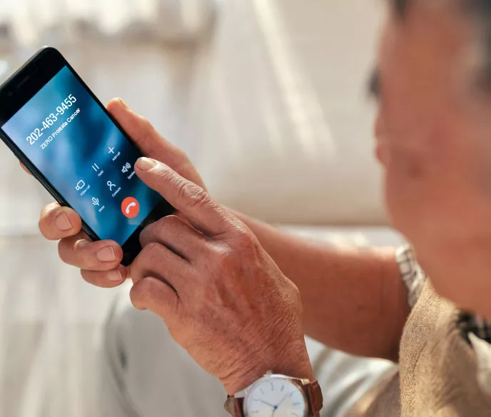 A man holding his phone and dialing ZERO