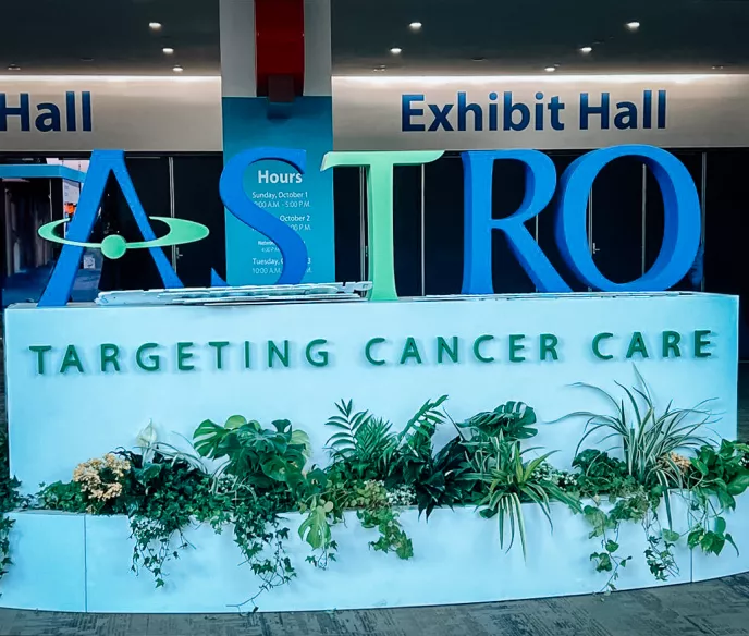 A sign at a conference with big letters spelling "ASTRO" and the base says "Targeting Cancer Care"