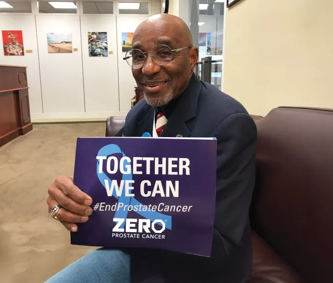 Man holding sign that says Together We Can End Prostate Cancer