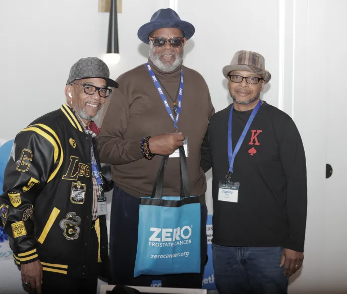 Three people smiling and standing shoulder to shoulder