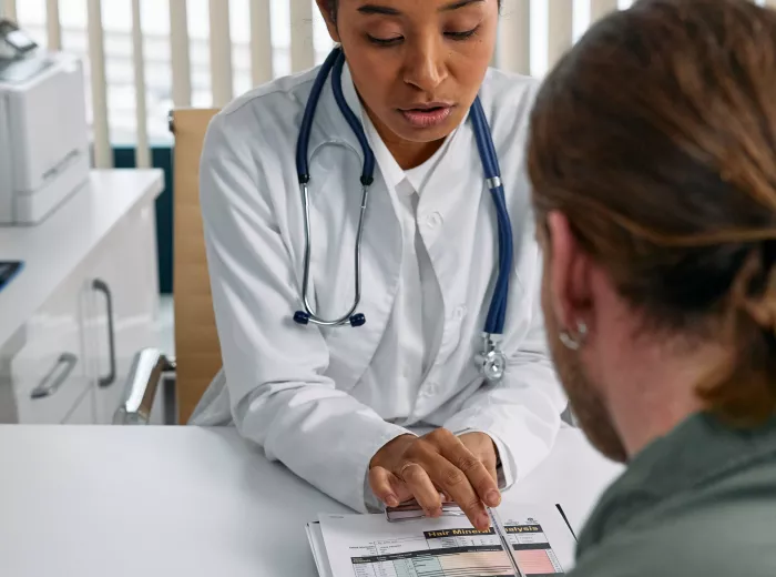 White female doctor reviewing patient's file with a male patient