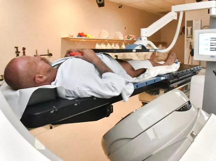 A man laying on a medical table receiving medical treatment