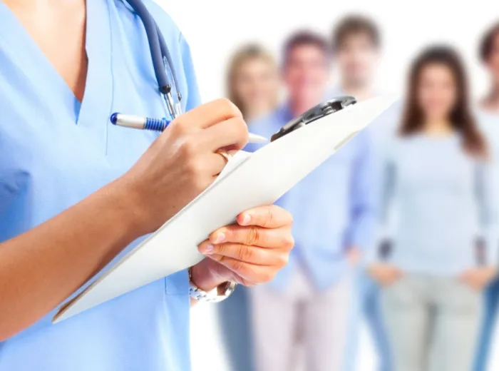 Medical professional holding a chart in front of a group of people