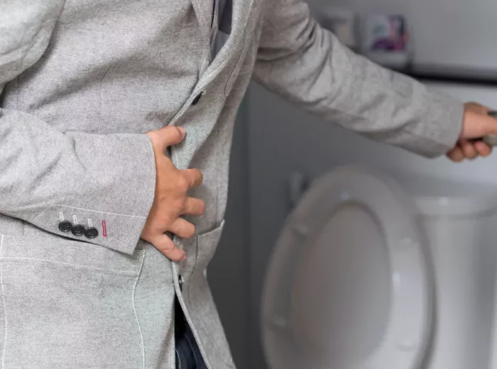 Men in a grey suit in a toilet