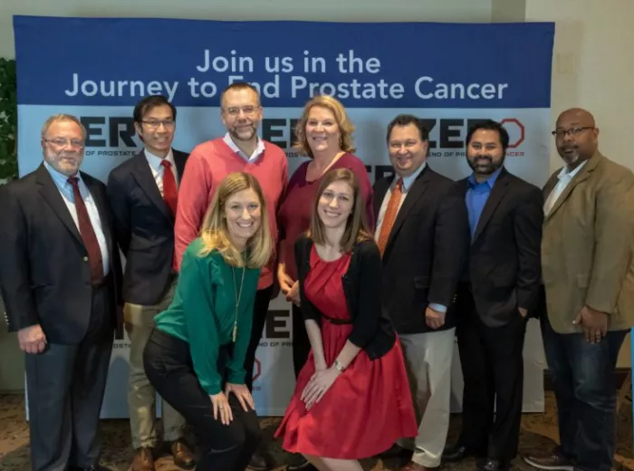 Group of people posing in front of a banner